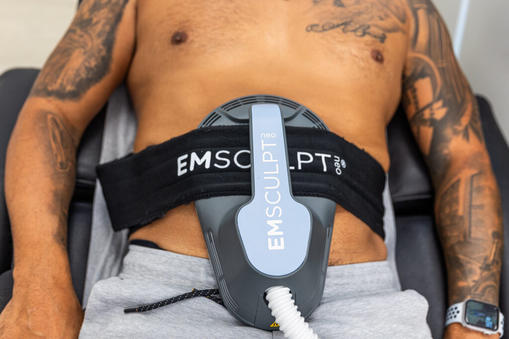 Close up of a man receiving an Emsculpt NEO abdomen treatment because it's the best way to get rid of dad body in Winter Garden.